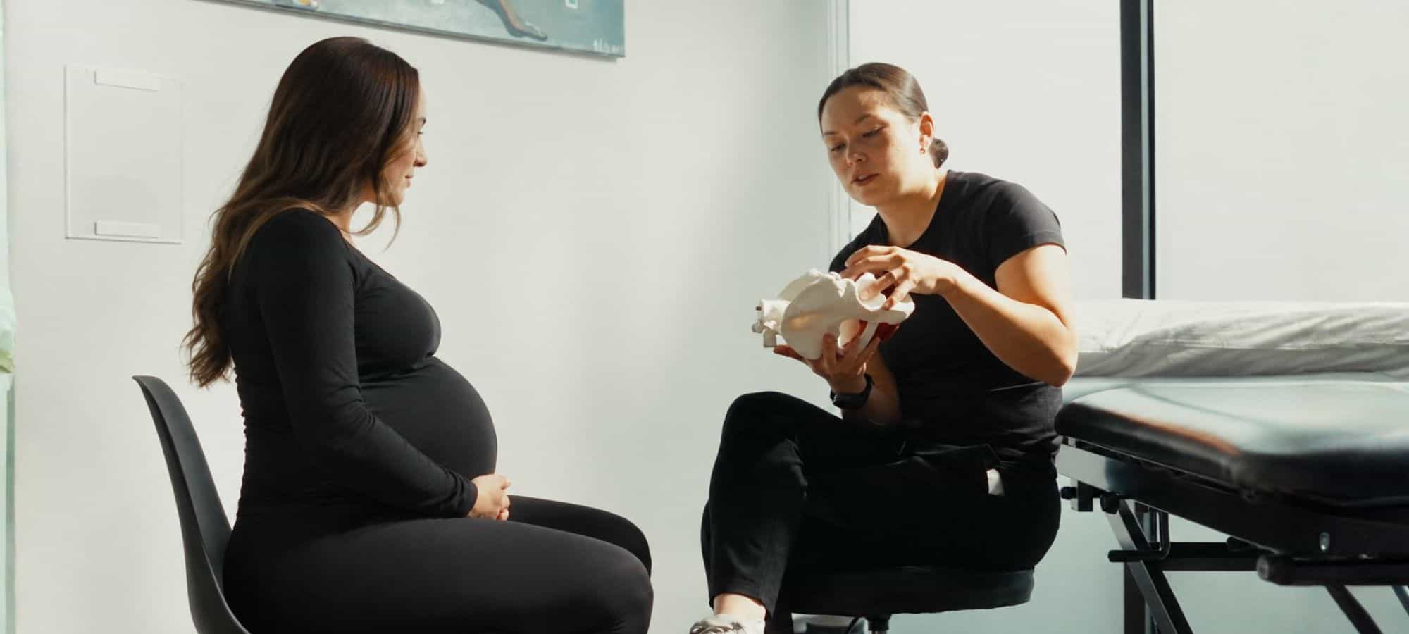 Pregnant woman consulting with physiotherapist in Victoria BC.