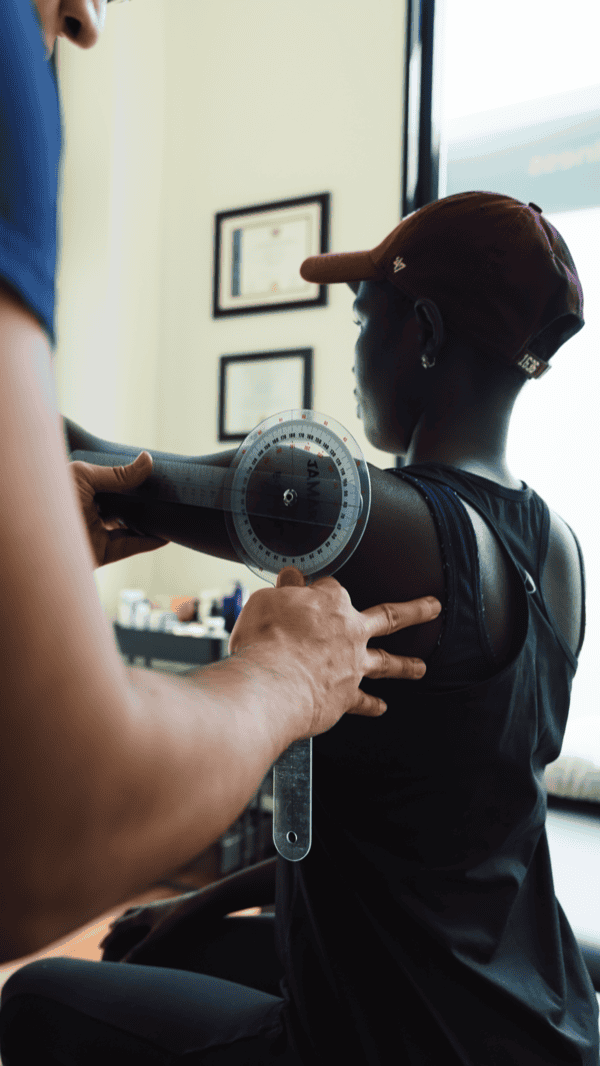 Physiotherapist measuring shoulder range of motion for injury assessment.