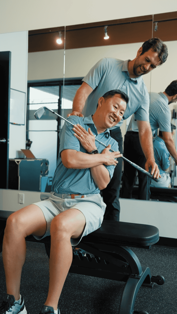 Physiotherapist assisting a patient with shoulder rehabilitation exercises.