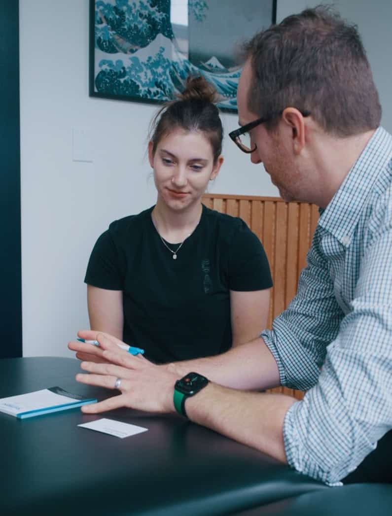 Physiotherapist consulting with a patient during a therapy session at South Island Physiotherapy.
