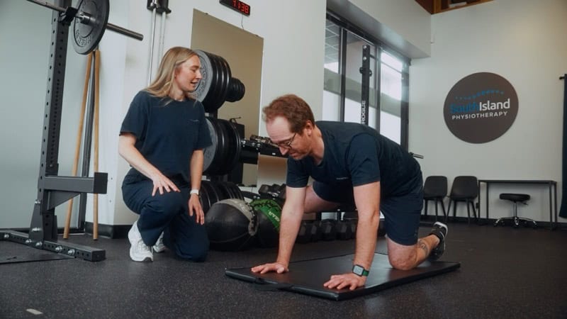 Physiotherapist assisting a patient with core exercises in a modern clinic.