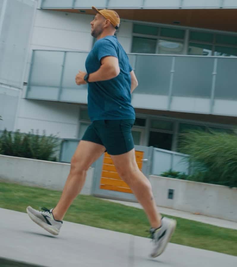 A man jogging outside near a modern building, promoting physical activity and physiotherapy services.